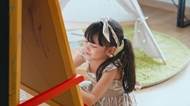 Slow motion Little Asian girl drawing on a canvas enjoying creative time