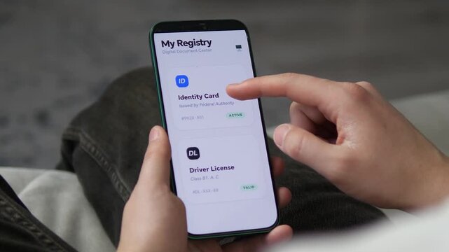 Close-up of a user accessing their digital ID and driver's license on a smartphone. Modern app UI shows active document status. Perfect for digital government, identity verification, and tech-driven
