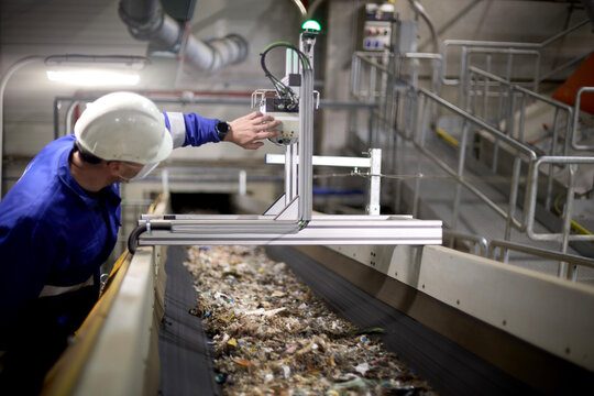 Industrial staff member observing material flow in RDF manufacturing operation.
