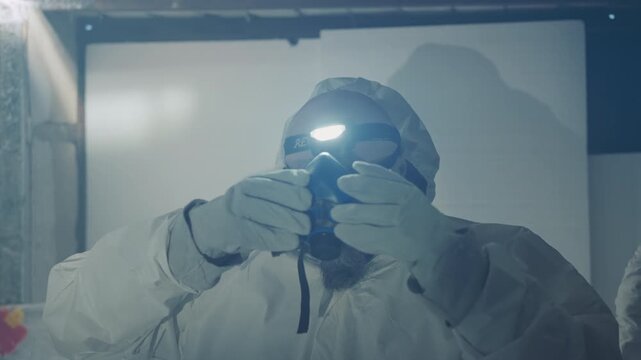 White technician dons respirator and headlamp in confined cold interior sequence shows operator fitting mask, medic checking seal, survivor taking steady breath with frosted beard, closeup portrait