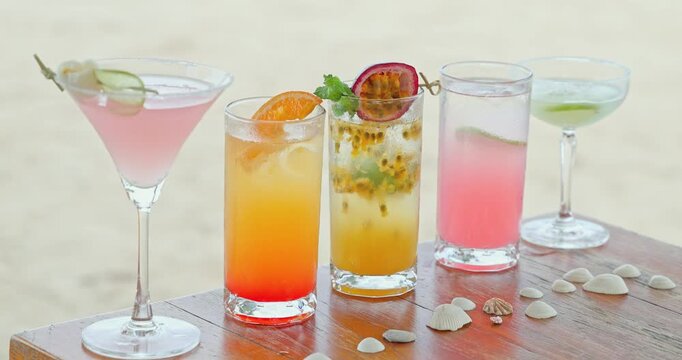 Tropical cocktails including passionfruit, Passiflora edulis, resting on wooden table, beach resort setting with sand and seashells, summer beverage menu for hospitality and travel marketing