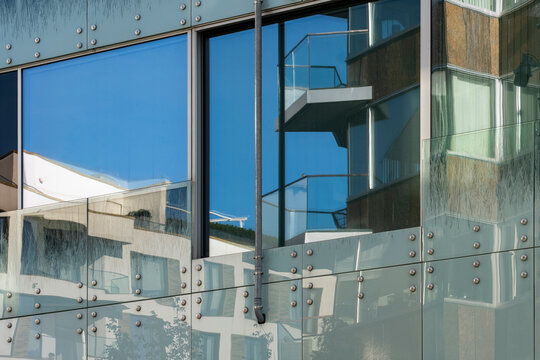 Glass facade with window reflection on modern urban architecture showing panels details and precise alignment in daylight