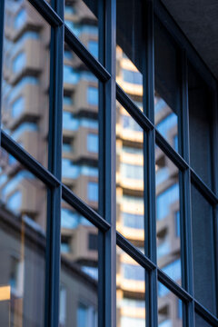 Blue glass window reflection on modern urban architecture showing building facade pattern with crisp lines and depth