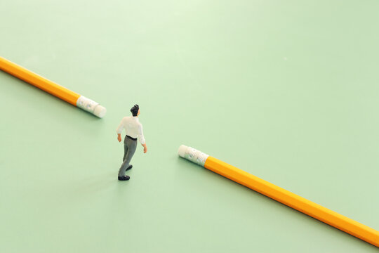 concept image of education as a barrier breaker. miniature figure crossing a barrier