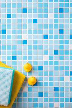 Set of baby bath accessories on blue and white mosaic tiles background.