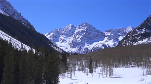 Maroon Bells Snowy Aspen Colorado Winter Spring time North Maroon Peak Rocky Mountains Maroon Lake snowmobile hiking deep snow powder sunny morning blue sky Capitol Peak Lazy 7 ranch tour zoom in
