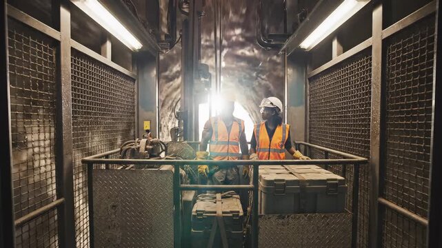 Mine elevator underground shaft industrial safety worker hard hat reflective vest metal cage heavy equipment transport construction site teamwork in harsh conditions underground tunnel