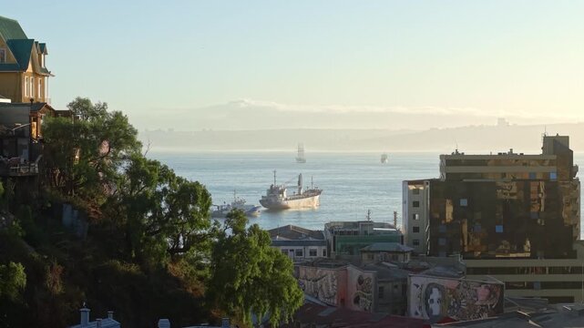Aerial tilt up Coastal landscape, Cargo ship in the bay of Valpara&iacute;so Chile, beautiful ship background training ship Chilean navy