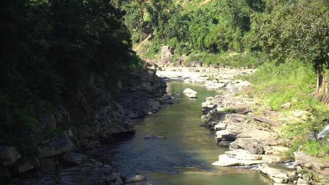 A fast-flowing river flows between two mountains in Mizoram