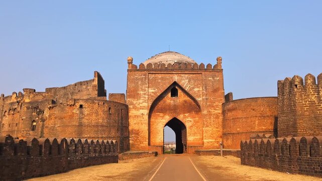 Reveal shot of Gumbad Darwaza with 40fts fort side wall and sky at bidar, karnataka, india. day time, tilt up shot, 4k.
