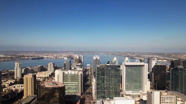 Drone flying west above downtown San Diego at 9AM moving toward the harbor with clear morning visibility.