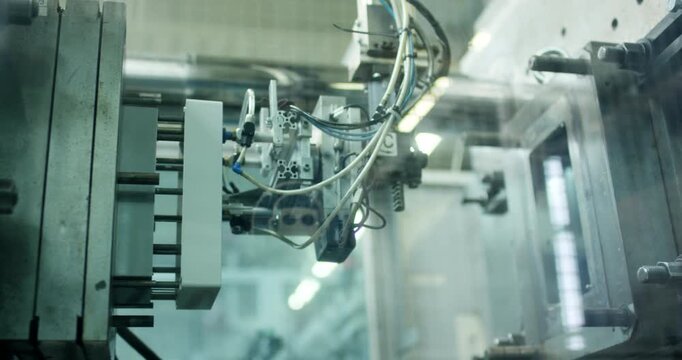 Detailed view of automated industrial machinery with cables and pneumatic components in a factory