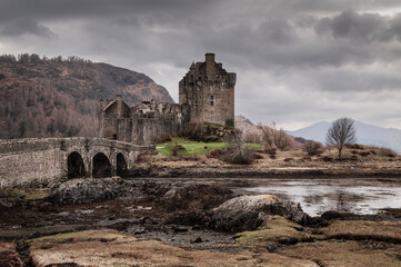 Eilean Donan castle and arched bridge stand majestically against a backdrop of rugged Scottish Highlands and moody clouds © David