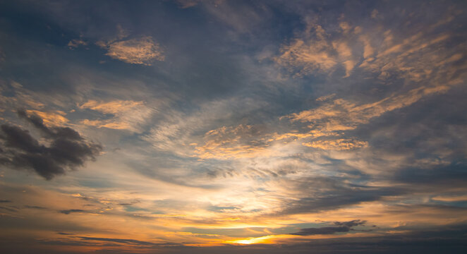 Dramatic sunset sky with golden clouds and vibrant twilight gradient.