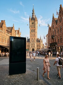 Digital advertising screen on cobblestone street in ypres