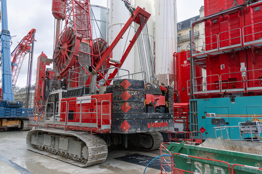 Paris, France - February 4th 2020 : View on a red duty cycle crawler crane Liebherr HS 855 HD for special foundations on a construction site.	