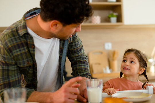 Father and daughter having conversation during breakfast at home
