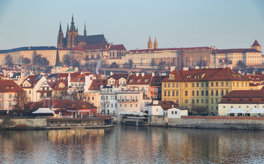 Fototapeta premium scenic view of Prague Castle and Charles Bridge glowing in golden light over the Vltava River