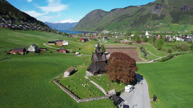 Urnes Stave Church with graveyard and farms in Luster Norway green valley near Lustrafjord