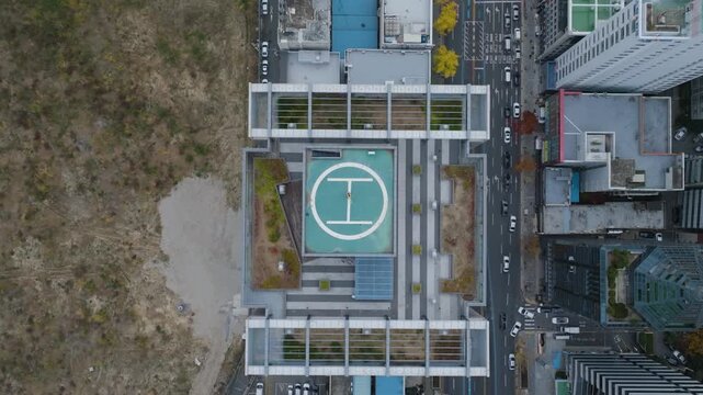Top down drone shot above a helipad with people standing on it in Busan, South Korea