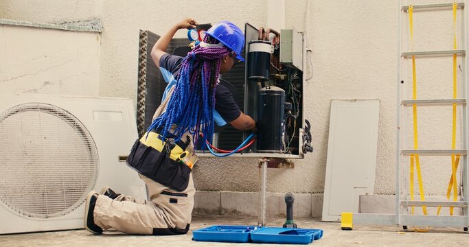 Capable electrician preparing for yearly condenser maintenance. Meticulous wireman unpacking toolset box with professional gear needed to repair faulty air conditioner internal components