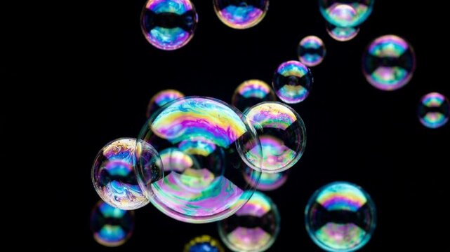 colorful soap bubbles floating in the air against a black background