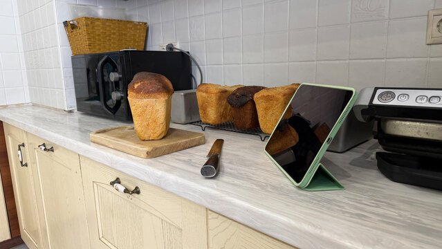Sourdough bread with tablet in modern kitchen