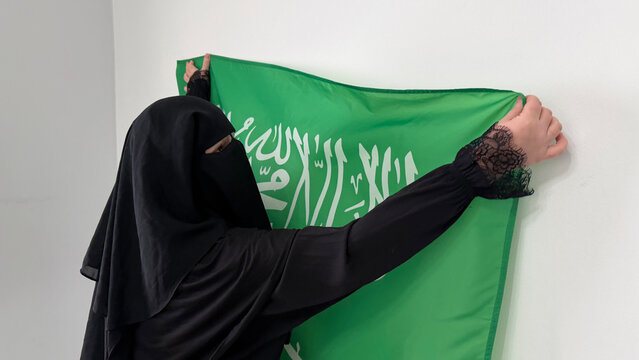 Saudi Arabia woman holding national flag close-up