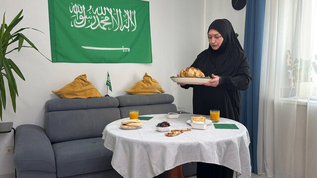 Saudi Arabia woman serving Kabsa rice with chicken during Ramadan
