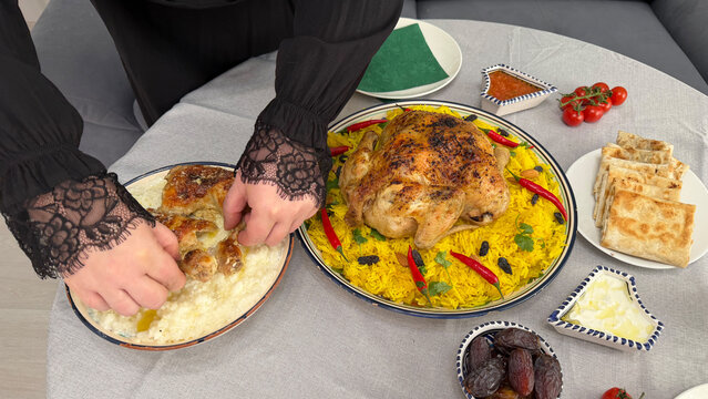 Woman eating saleeg rice with chicken during traditional meal