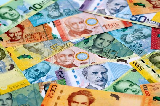 Costa Rican colon money banknotes pile on table. Costa Rica bills of CRC currency close up