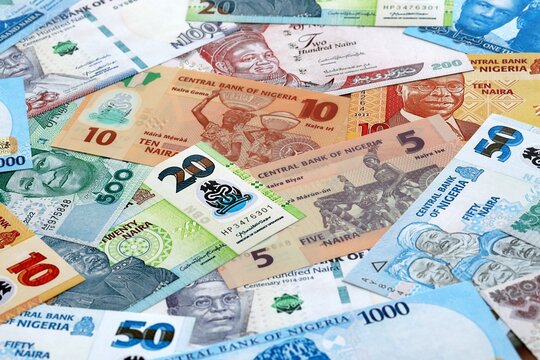 Nigerian naira money banknotes pile on table. Nigeria bills of NGN currency close up