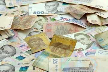 Obraz premium Ukrainian hryvnia money banknotes pile on table. Ukraine bills of UAH currency close up