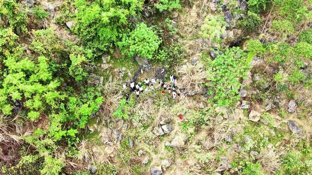 Cinematic Drone: Guangxi Qingming, Group of People Hiking Up Karst Mountain to Sweep Ancestral Tomb