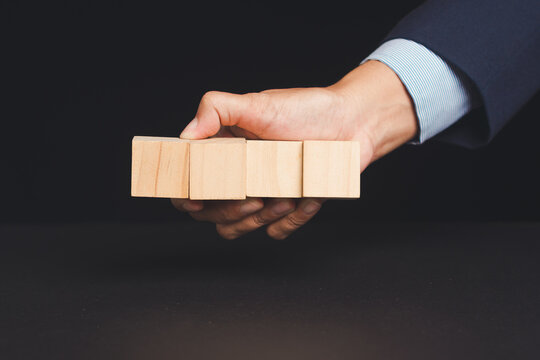 Business person holding wooden blocks for strategy concept