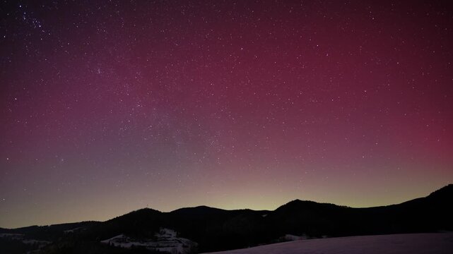 Timelapse of Pink Aurora Borealis Glowing Over Winter Mountain Range