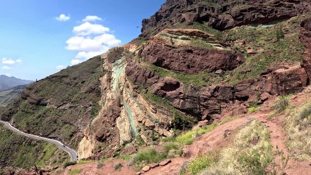 POV walking shot of Los Azulejos rainbow rocks and expansive mountain valley Gran Canaria