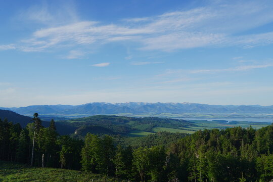 Liptovska Mara, Slovakia, between Tatra mountains. Panoramic View of Mountain Range and Lake Over Lush Green Forest Canopy.