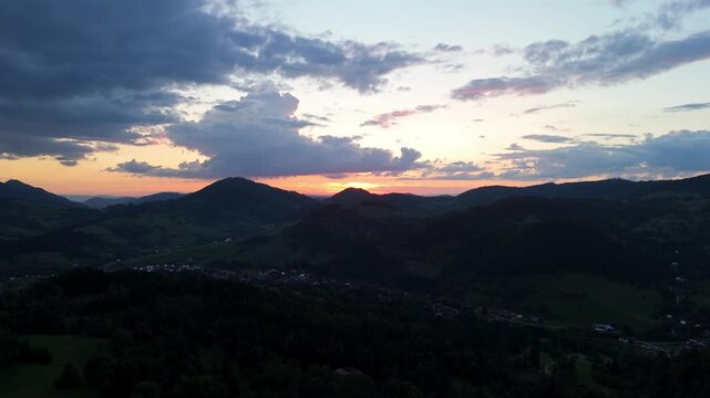 Aerial view of mountain landscape at sunset with clouds and forest