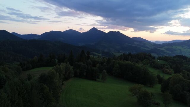 Sunset mountain peaks and green forest aerial view