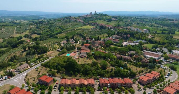 Stunning aerial panorama of Italian villas and vineyards. Panoramic slide forward showing red roofs, green cypress trees, and cultivated fields. Scenic summer travel destination in the heart of Italy.