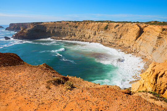Rolling waves in the bay off Carrapateira. Steep coastline on the Algarve, Portugal.