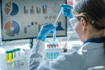 Female researcher in modern laboratory uses pipette to transfer liquid samples, focusing on scientific analysis. Laboratory glassware, digital data visualization highlight advanced research methods © YURIMA