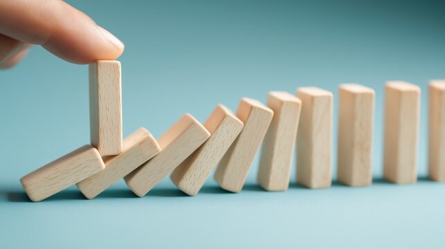 risk management and business protection concept, hand stopping falling domino effect chain reaction with wooden blocks, crisis control strategy and problem prevention background with copy space