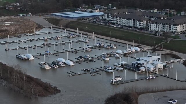 Aerial view of various boats docked in the marina with modern buildings in the background, contrasting with the water, Dayton, Kentucky, United States.