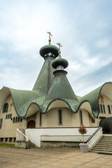 Holy Trinity Orthodox Cathedral with green copper onion domes and wavy roof, Hajnowka, Poland © Art L