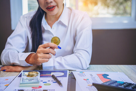 Businessman holding Bitcoin for digital currency trading at his workplace. Bitcoin and digital money concept.