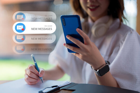 Woman checking new message notifications on smartphone while writing multitasking to manage digital communication and stay connected new message email technology
