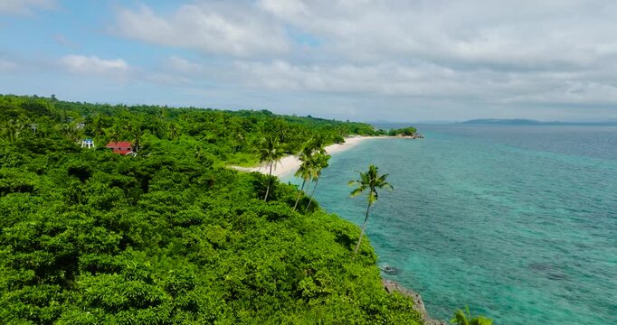 Tropical beach with coconut trees and clear turquoise water in Carabao Island, Romblon. Philippines.