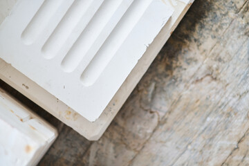 Close up of white moulded plaster decorative trim with stepped profile on wooden surface for interior design and construction detail. Manufacture and construction of moulds  © dannyburn